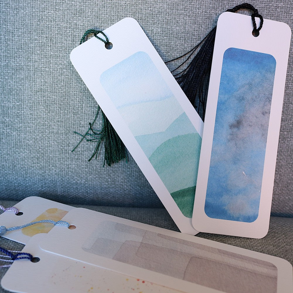 Berlin-Lesezeichen mit abstrakten Aquarellhintergründen in Blau- und Grüntönen, Detailansicht mit Quasten.