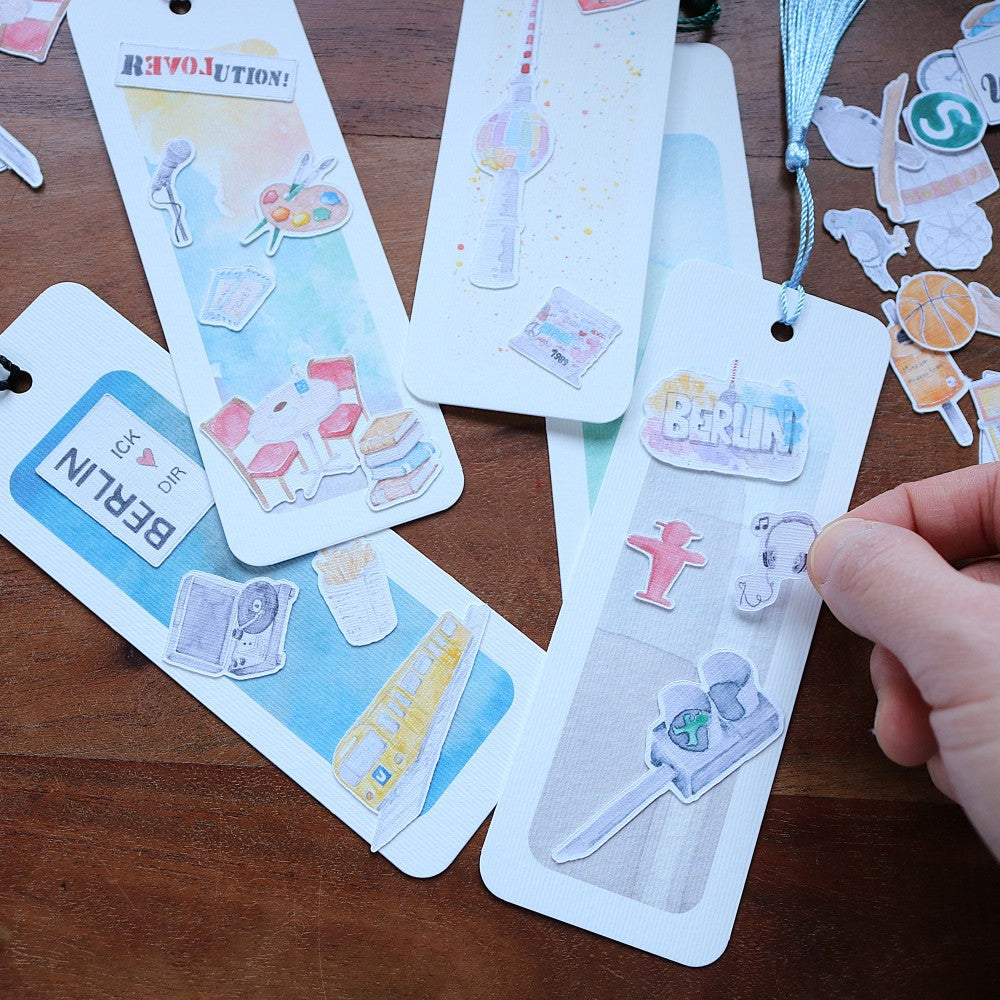 Lesezeichen-Set Berlin mit Aquarellillustrationen, gestaltete Lesezeichen mit Berliner Motiven in der Hand
