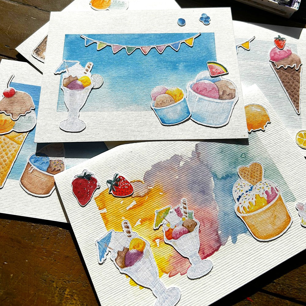 Karten mit Motiven zum Thema Eis, Eiswaffeln, Becher und bunte Girlanden, liegend auf einem Tisch