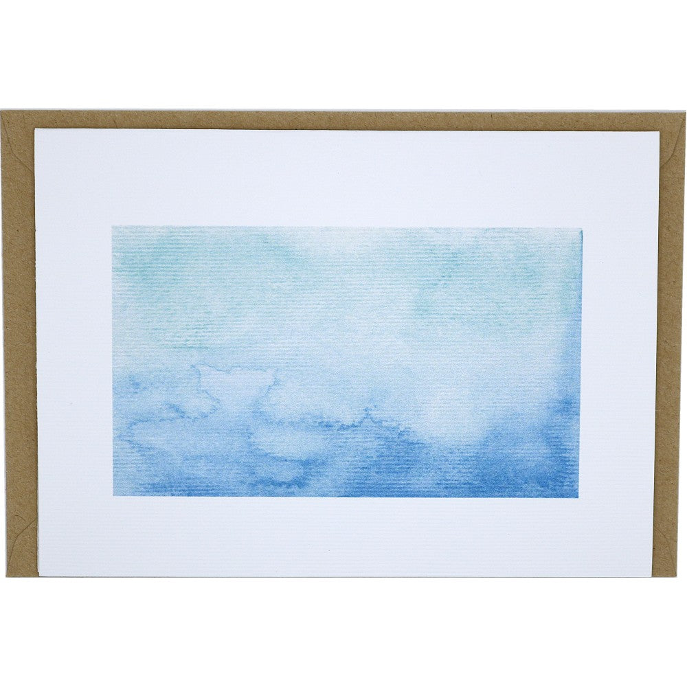 Aquarell Postkarte aus strukturiertem Aquarellpapier mit blauem Meeresverlauf, dazu ein liegender Umschlag aus Kraftpapier.