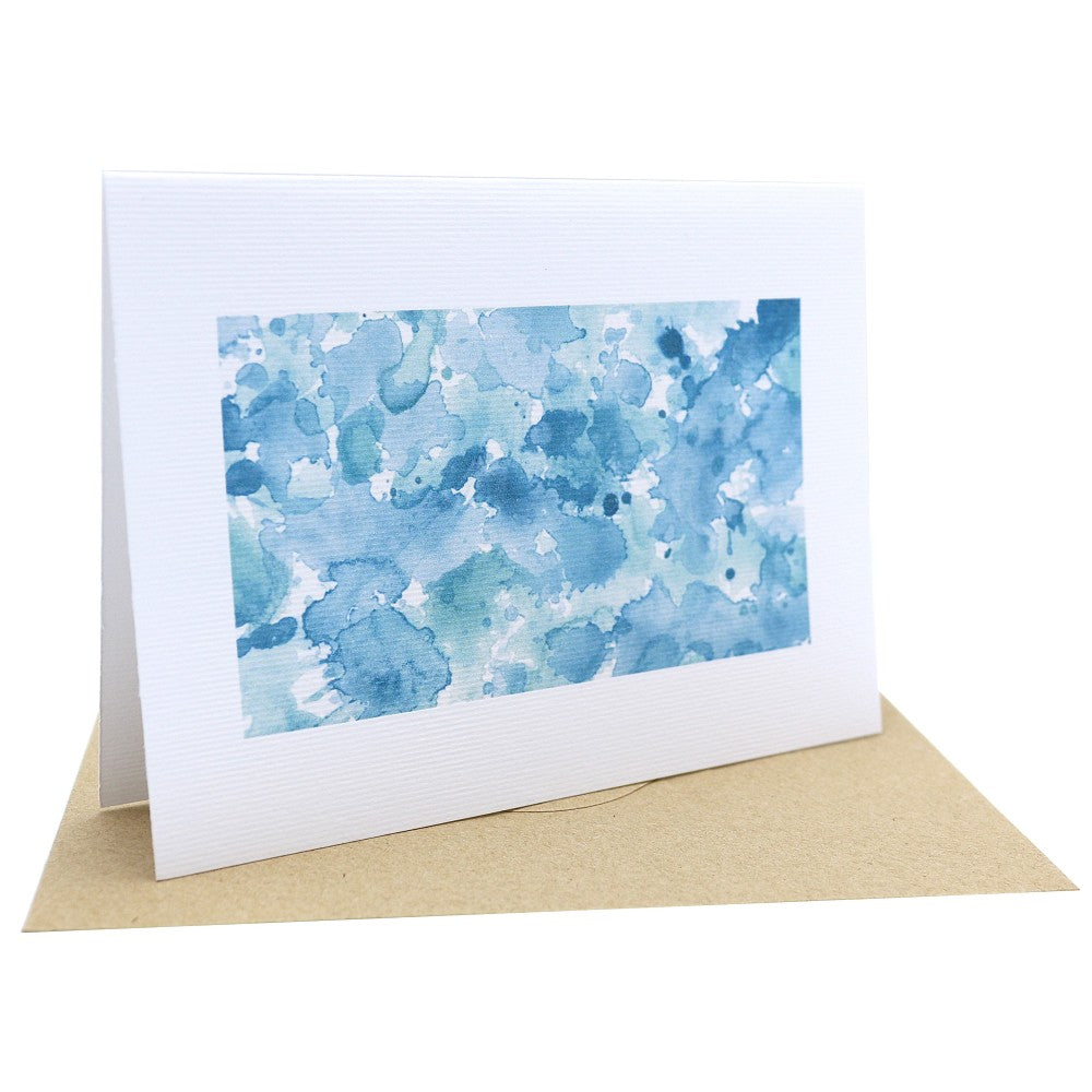 Aquarell-Klappkarte Im Meer mit lebhaften Blautönen, die an sprudelnde Wellen und Meerestropfen erinnern; auf strukturiertem Aquarellpapier, kombiniert mit einem naturfarbenen Kraftpapierumschlag.