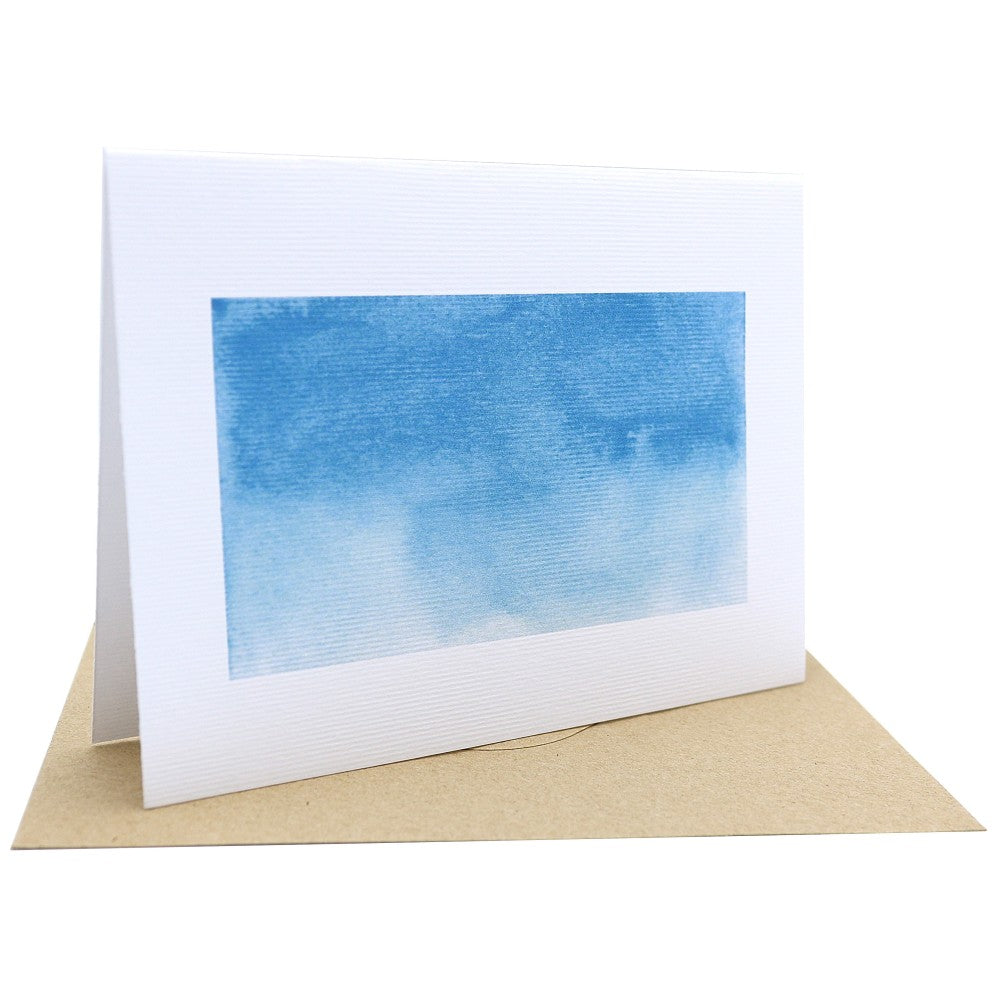 Klappkarte „Im Meer“ mit einem blau-weißen Aquarellmotiv in sanften Wellen- und Wasserverläufen; auf strukturiertem Aquarellpapier, kombiniert mit braunem Kraftpapier-Umschlag; aufgestellt fotografiert.

⸻
