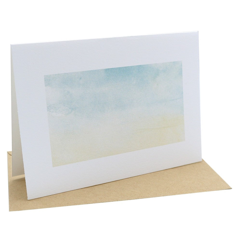 Tropenwelt Klappkarte mit Aquarell Hintergrund in Blau Beige, stehende Karte mit liegendem Kraftpapier Umschlag dahinter