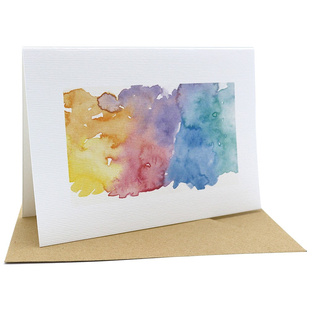 Einzelne Klappkarte mit mehrfarbigem Aquarell-Hintergrund in Gelb-, Rosé-, Violett- und Blautönen, auf Kraftpapier-Umschlag
