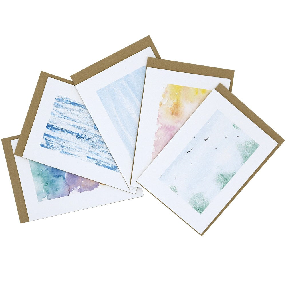 Übersicht von fünf Aquarellkarten mit abstrakten Aquarell-Hintergründen, jeweils mit naturfarbenem Kraftpapier-Umschlag im Hintergrund