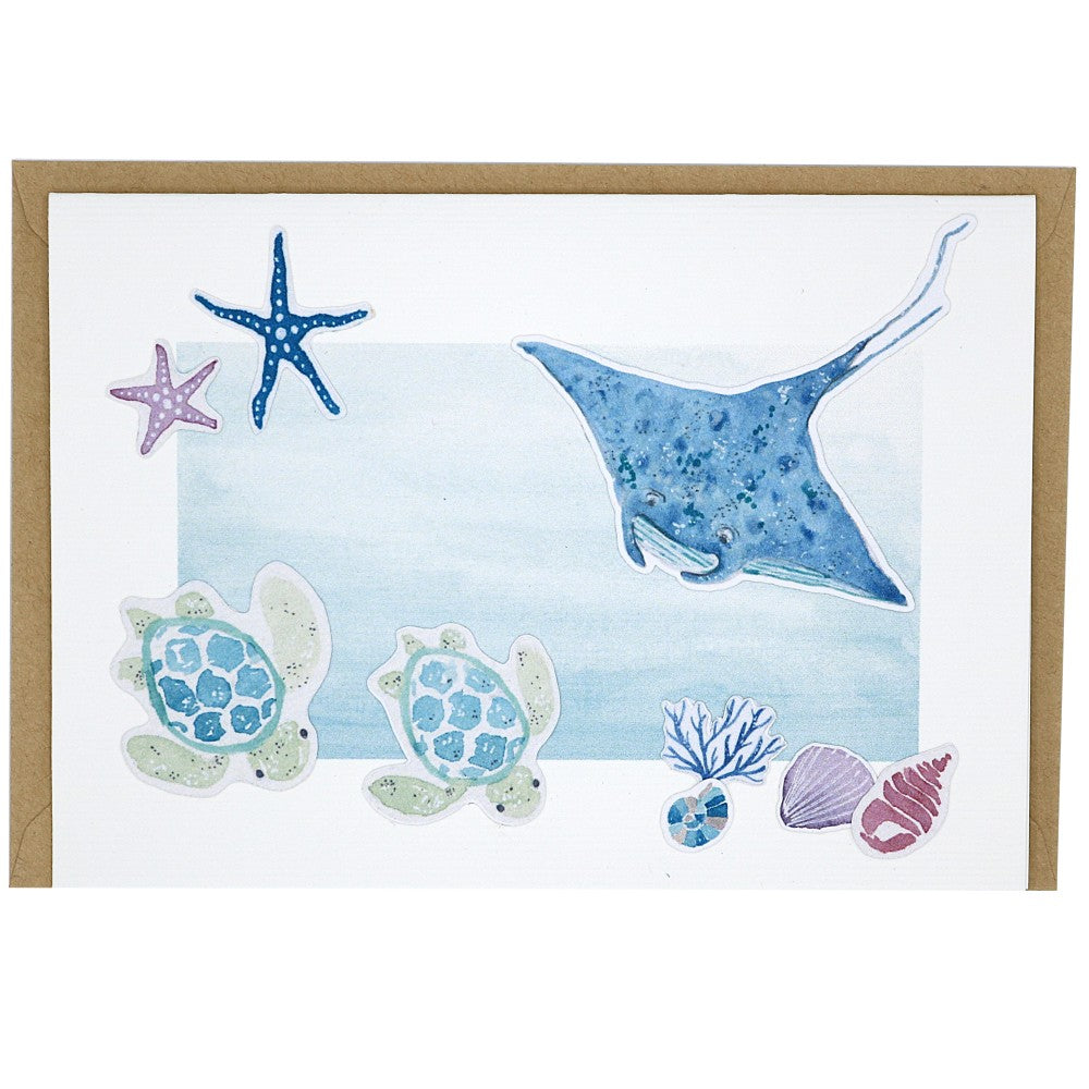 Grusskarte maritim mit Rochen und Schildkröten, dahinter ein Kraftpapier Umschlag