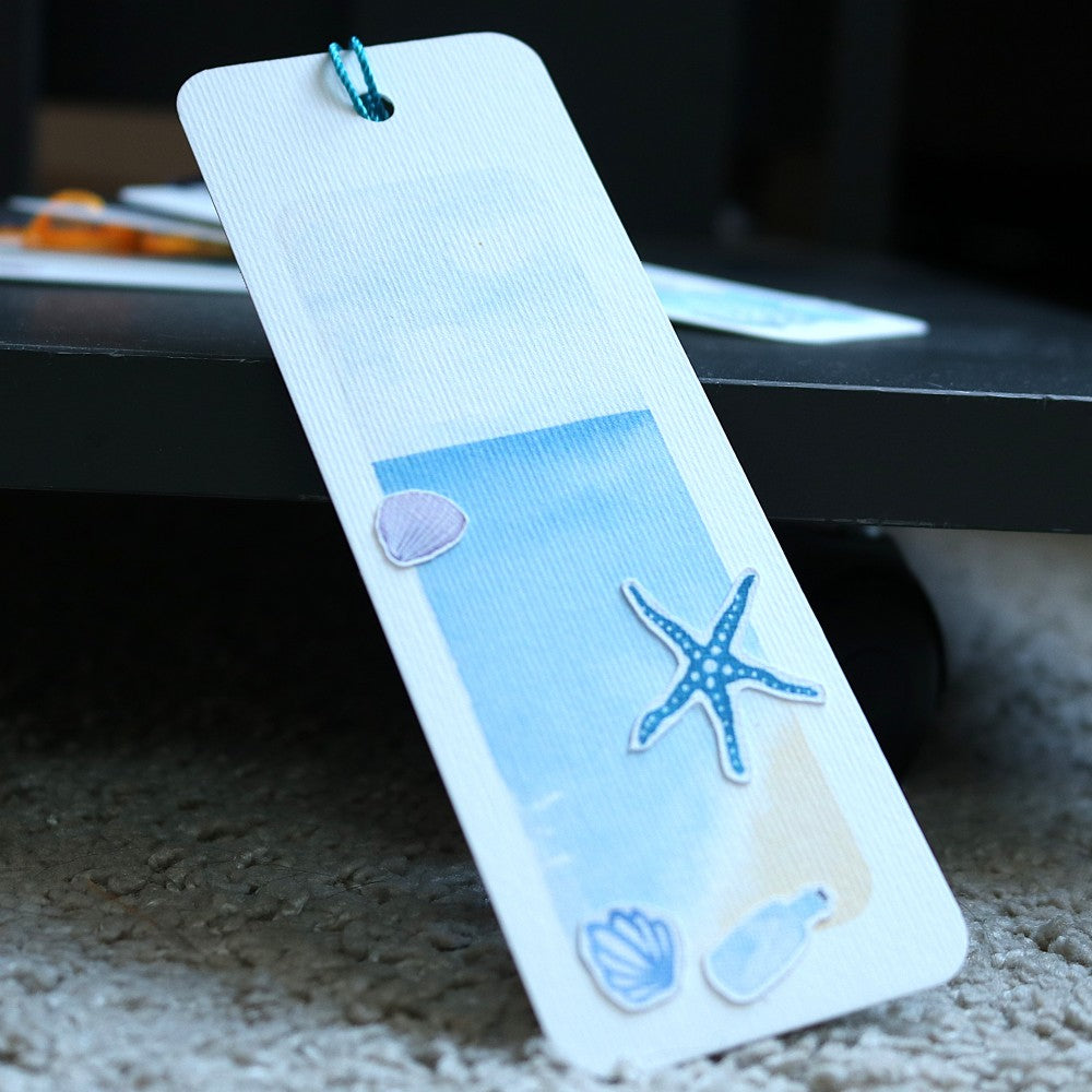 Lesezeichen Im Meer: Blaues Aquarell-Lesezeichen mit Seestern, Muschel und kleinen Meeresmotiven zum Selbstgestalten