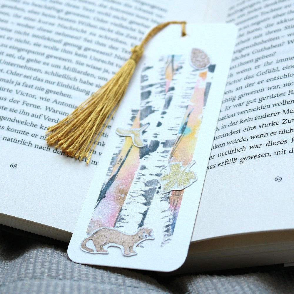 Lesezeichen Waldbewohner: Aquarell-Lesezeichen mit Birkenwald-Hintergrund und Waldbewohner-Motiven wie Marder und Blättern, mit goldfarbener Quaste