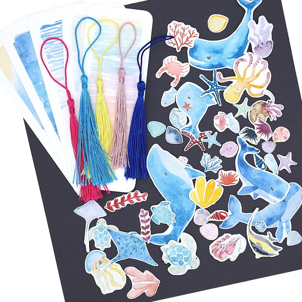Kreativset Meer: Übersicht aller enthaltenen Meermotive wie Wale, Fische, Korallen und Muscheln sowie fünf Lesezeichen mit maritimen Wasserfarben und bunten Quasten.