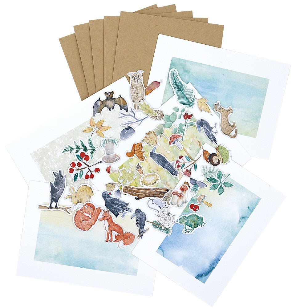 Kreativset aus der Waldbewohner-Kollektion mit mehreren Postkarten auf strukturiertem Aquarellpapier, passenden Kraftpapier-Umschlägen und einer Auswahl an Aquarellmotiven wie Tieren, Blättern und Waldillustrationen, dekorativ ausgelegt