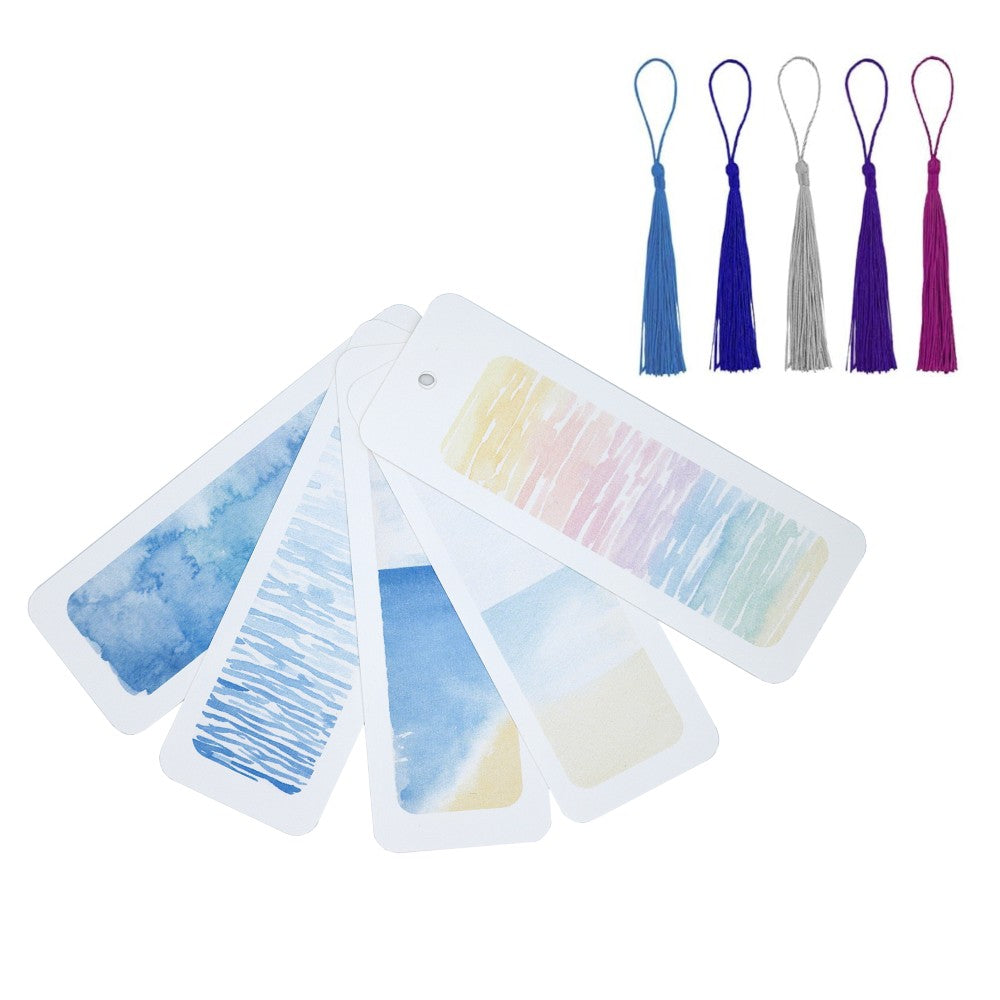 Set aus fünf maritimen Aquarell-Lesezeichen in Blau- und Pastelltönen, fächerförmig ausgebreitet. Darüber liegen fünf passende Quasten in Blau, Violett und Grau. Helle, luftige Darstellung vor weißem Hintergrund – zeigt alle Varianten des Sets Im Meer auf einen Blick.